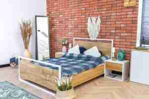 białe łóżko z drewna i metalu