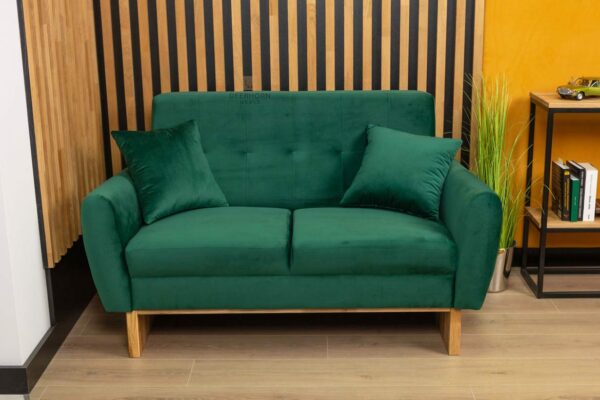 sofa butelkowa zieleń z poduszkami i drewnianymi nogami