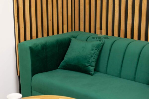 elegancka sofa z poduszkami w kolorze butelkowej zieleni