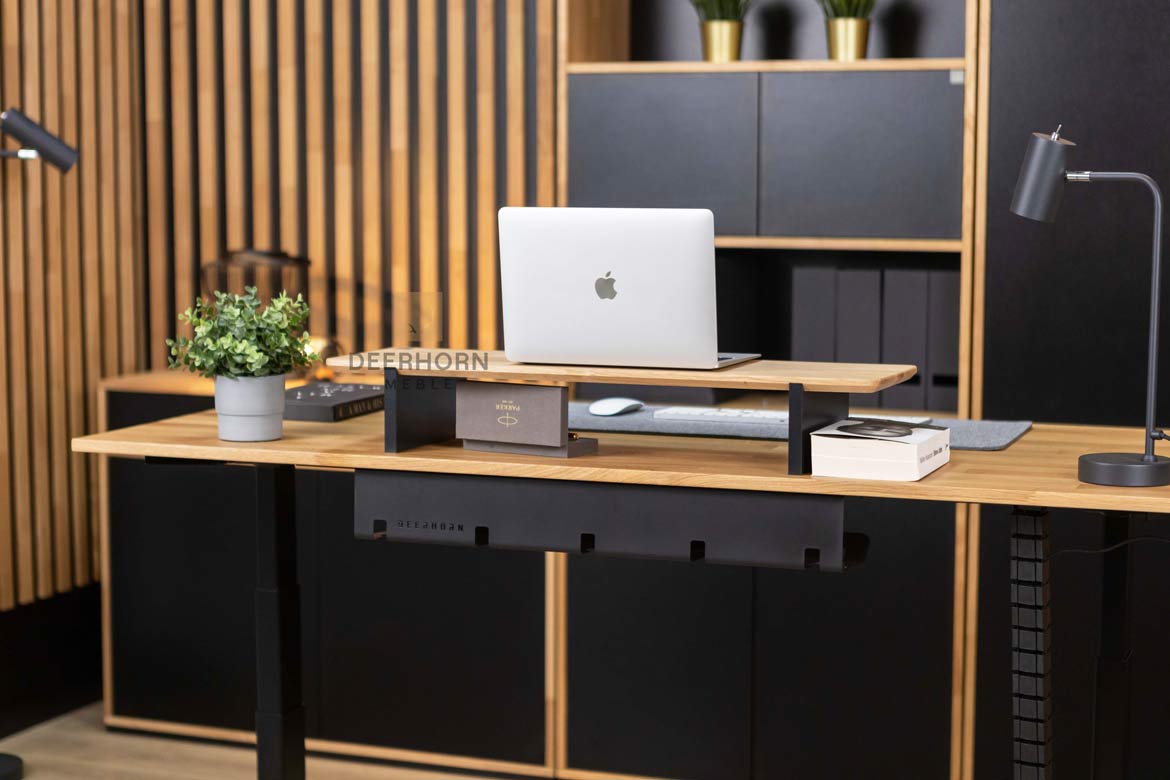 Biurko z wyjątkowym drewnianym blatem i solidnymi metalowymi nogami, będące centralnym punktem pomieszczenia, w którym znajdują się meble biurowe