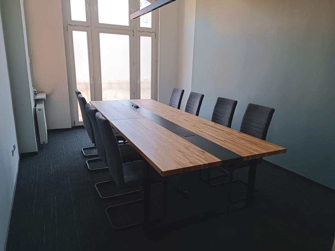 pomieszczenie biurowe z długim stołem konferencyjnym
