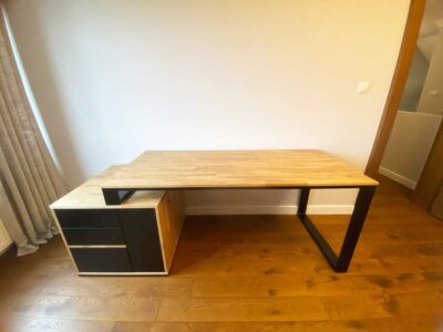 biurko z drewnianym blatem, metalowymi nagami i czarnym kontenerkiem z szufladami po lewej stronie