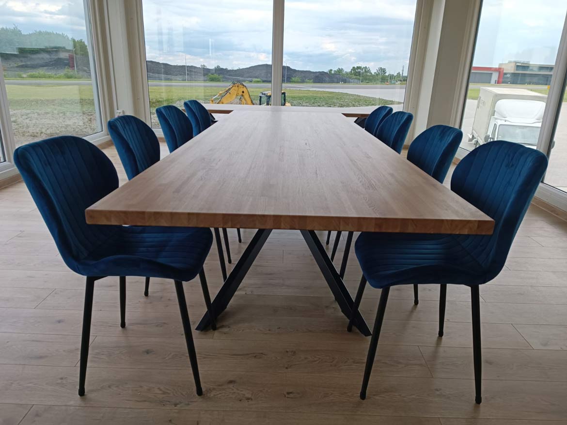 drewniany stół konferencyjny z 12 niebieskimi krzesłami