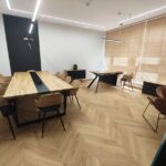 Nowoczesne biuro z dużym stołem konferencyjnym i biurkiem przy oknie