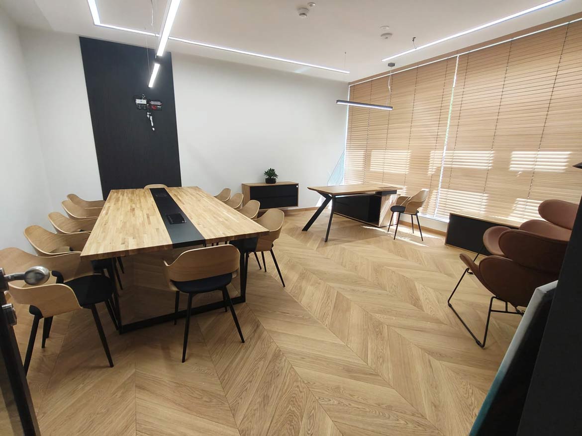 Nowoczesne biuro z dużym stołem konferencyjnym i biurkiem przy oknie