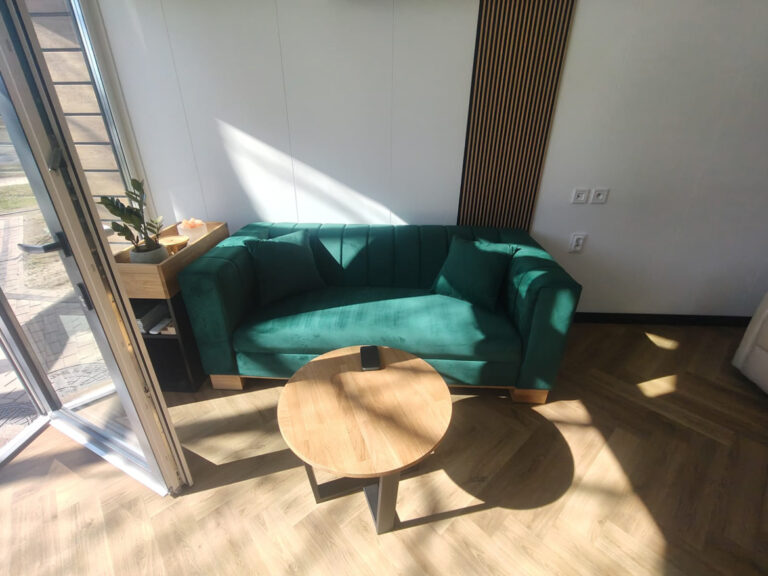 Strefa wypoczynku z sofą w kolorze butelkowej zieleni dla firmy PORT ROLniczy w Świdnicy