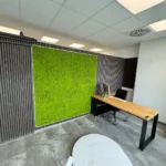Biurko narożne Modern Office przy zielonej ścianie z mchu dla szkoły jazdy ZERO z Friedrichshafen (Niemcy)