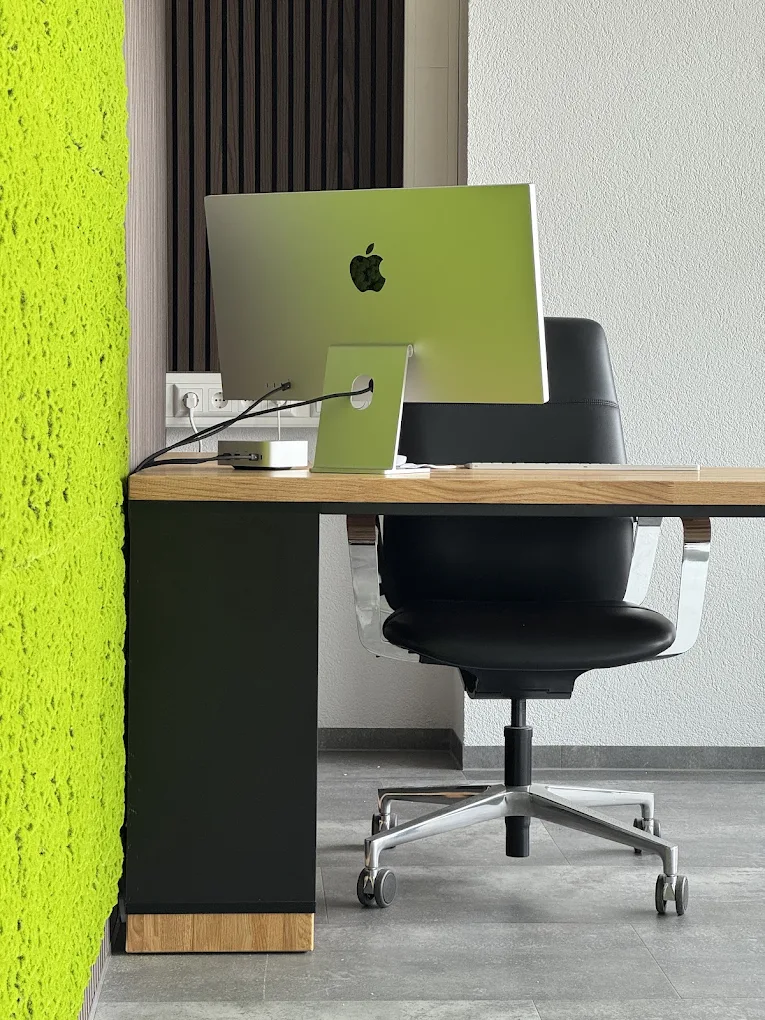 Biurko narożne Modern Office przy zielonej ścianie z mchu dla szkoły jazdy ZERO z Friedrichshafen (Niemcy)